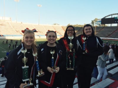 Drum majors, Victoria Brown and Haley Workman, and flag captains, Ryleigh Evans and Anna Roussel, pose with their trophies.